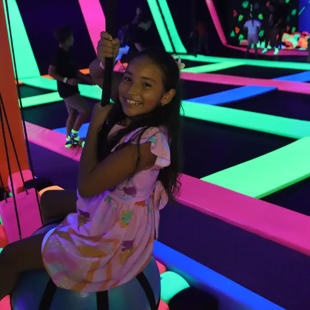 Menina sorrindo em uma atração sobre a piscina de espuma do Smiley Park
